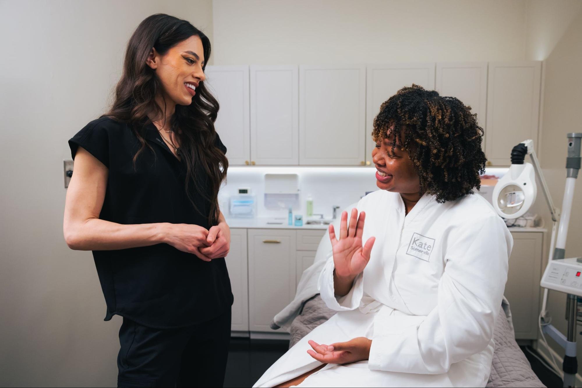 A smiling client is speaking with a self-care professional prior to their appointment.