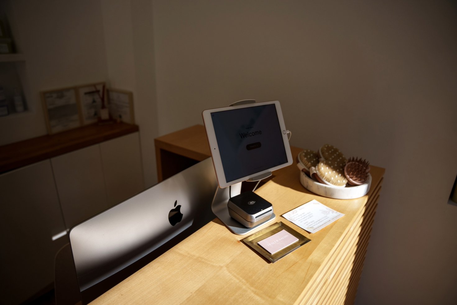 A payment station prominently displayed at the front desk of a self-care business.
