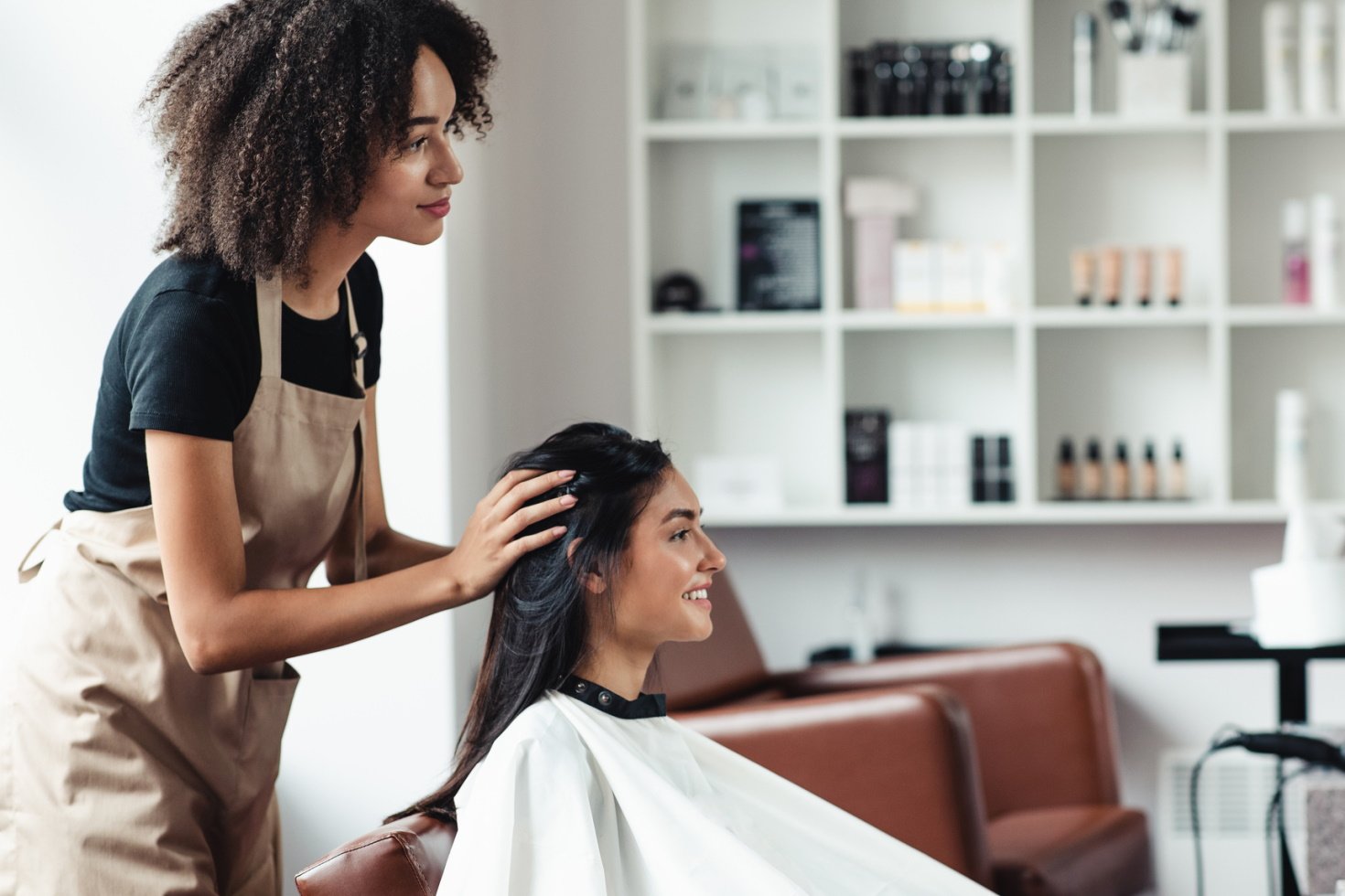 A stylist gets ready to cut a woman's hair.