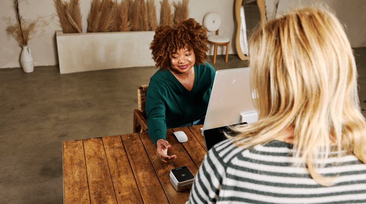 A woman checks out at the front desk of a medspa.